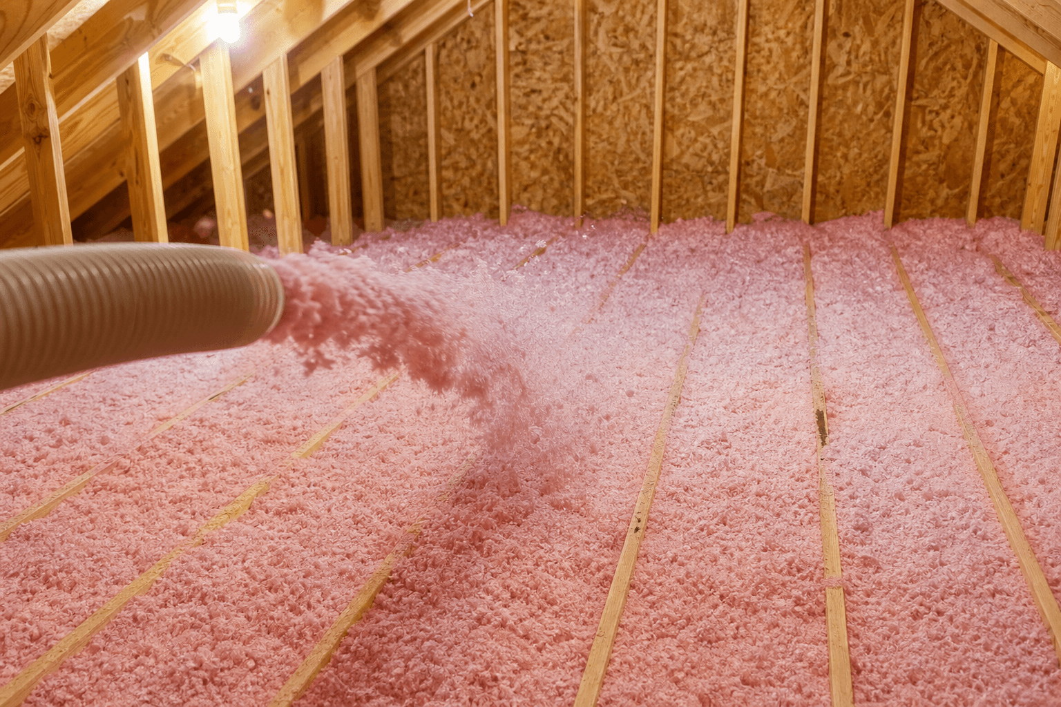Blown-in attic insulation being installed between joists after remediation